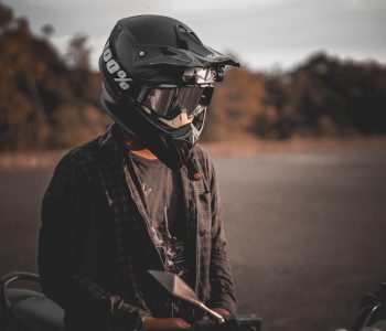 homme debout sur une moto et portant un casque