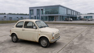Une voiture française ancienne garée devant une usine automobile moderne dédiée à la production de véhicules électriques, illustrant le contraste entre patrimoine et innovation.